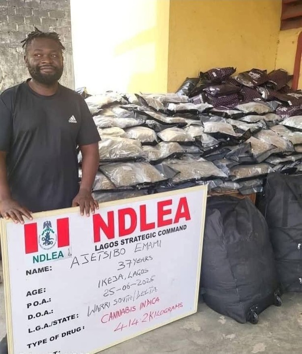 Young man smiling during NDLEA arrest holding a board