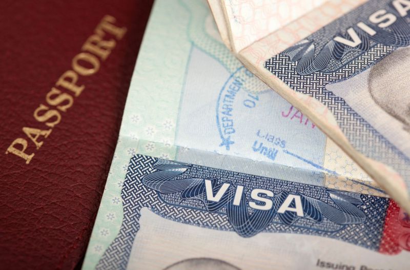 U.S. passport and visa with U.S. dollar bills, symbolizing visa bond up to $15,000 requirement