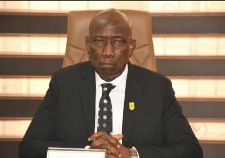 DIG Johnson Kokumo speaking at a press briefing in front of intercepted automatic rifles.