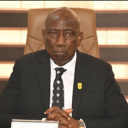 DIG Johnson Kokumo speaking at a press briefing in front of intercepted automatic rifles.