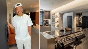 Terence Cao sitting inside his newly renovated industrial-style dining area next to a black granite island.