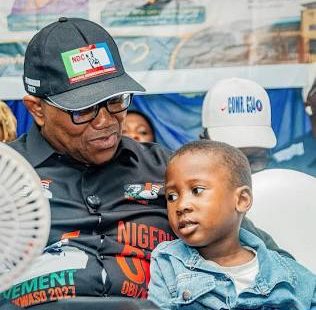 Peter Obi sitting alongside a young child during the medical outreach celebrating his 65th birthday.